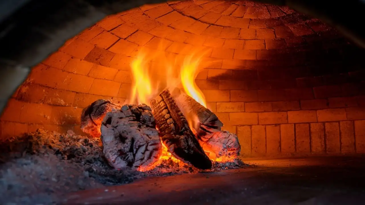 firewood burning in a brick pizza oven